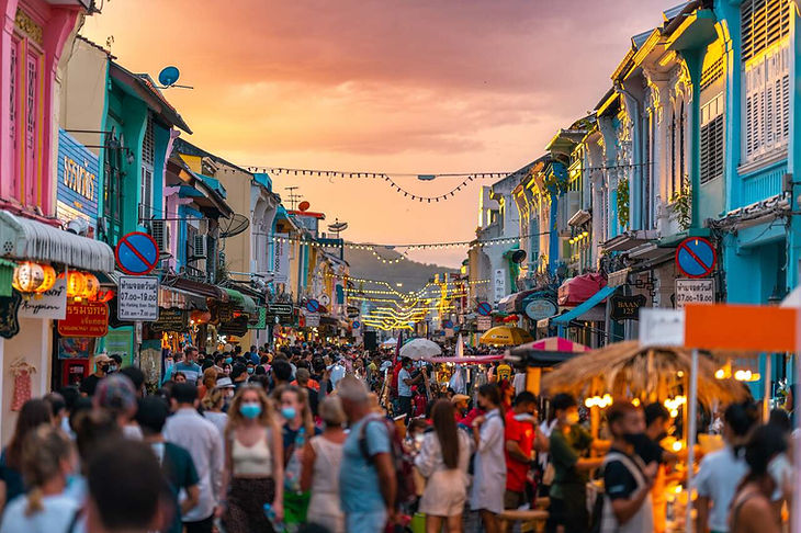 Phuket Old Town walking street at sunset — pastel shophouses, lanterns, market crowd